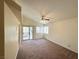 Bright living room featuring a ceiling fan, carpeted floors and sliding glass doors leading to an outdoor patio at 1301 Misty View Ct, North Las Vegas, NV 89031
