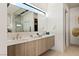 A modern bathroom with a large double vanity, and stylish fixtures, and a unique mirror at 1572 Pleasant Bay Ct, Henderson, NV 89011