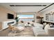 A bright living room with a modern fireplace, comfortable seating, and expansive lake views at 1572 Pleasant Bay Ct, Henderson, NV 89011