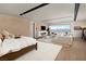 A bright main bedroom with a seating area, modern fireplace, and expansive lake views at 1572 Pleasant Bay Ct, Henderson, NV 89011