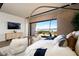 A light and airy main bedroom featuring a view of an outdoor lounge, a modern TV and comfortable seating at 1572 Pleasant Bay Ct, Henderson, NV 89011