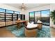 A bright home office with unique light fixture, decorative shelves, a large window and stylish chairs at 1572 Pleasant Bay Ct, Henderson, NV 89011