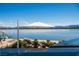 Relaxing poolside view with lounge chairs and umbrella overlooking a tranquil lake and distant mountains at 1572 Pleasant Bay Ct, Henderson, NV 89011