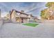 Enjoy this spacious backyard featuring turf area, gravel, mature trees, and privacy wall at 163 Spinnaker Dr, Henderson, NV 89015