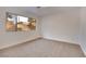 Sunlit bedroom with neutral carpet, a large window, and white walls, providing a serene and inviting space at 163 Spinnaker Dr, Henderson, NV 89015