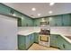 Modern kitchen with sleek green cabinetry, quartz countertops, and stainless steel appliances at 163 Spinnaker Dr, Henderson, NV 89015