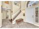 Inviting home foyer with a grand staircase and a bench seat, showcasing elegant tile flooring at 1912 Sierra Oaks Ln, Las Vegas, NV 89134