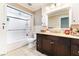 Bathroom featuring a shower-tub combo and a vanity with a dark-stained wood cabinet at 1920 Parkchester Dr, Las Vegas, NV 89108