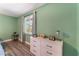 Green bedroom featuring a white dresser, wood floors and a bright window at 1920 Parkchester Dr, Las Vegas, NV 89108
