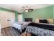Green bedroom featuring two beds with wooden floors and a ceiling fan at 1920 Parkchester Dr, Las Vegas, NV 89108