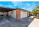 View of the attached garage with brick and stucco exterior, as well as a large driveway at 1920 Parkchester Dr, Las Vegas, NV 89108