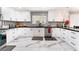 Well-lit kitchen with white cabinets, black countertop, stainless steel appliances and modern backsplash at 1920 Parkchester Dr, Las Vegas, NV 89108