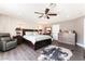 Spacious main bedroom with a decorative ceiling fan, dresser, and a leather recliner at 1920 Parkchester Dr, Las Vegas, NV 89108