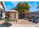 Outdoor patio featuring a gazebo, lounge chairs, and a hanging hammock with vibrant plants at 1920 Parkchester Dr, Las Vegas, NV 89108