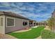 Backyard view showcasing a covered patio, lush green lawn, and privacy landscaping at 2602 Evening Sky Dr, Henderson, NV 89052