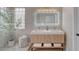 Modern bathroom featuring double sinks, sleek vanity, and glass block window for natural light at 2602 Evening Sky Dr, Henderson, NV 89052