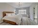 Spacious bedroom with wood-look floors, stylish chandelier, and natural light from a large window at 2602 Evening Sky Dr, Henderson, NV 89052
