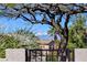 Exterior home view featuring mature trees, desert landscaping, and mountain views in the background at 2602 Evening Sky Dr, Henderson, NV 89052
