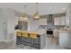 Island kitchen featuring modern appliances, stone backsplash, and island with stools at 2602 Evening Sky Dr, Henderson, NV 89052