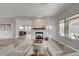 Open-concept living room featuring a modern fireplace, wood floors, and backyard views through large windows at 2602 Evening Sky Dr, Henderson, NV 89052