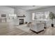 Bright living room with a modern fireplace, wood floors, and large windows offering backyard views at 2602 Evening Sky Dr, Henderson, NV 89052
