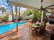 Beautiful backyard features a pool, hot tub, covered patio with a dining table, and desert landscaping at 3047 Whispering Crest Dr, Henderson, NV 89052