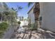 View of backyard, walkway with gated access, mature landscaping, and home exterior at 3047 Whispering Crest Dr, Henderson, NV 89052