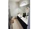 Bathroom with a double sink vanity, light wood floor, and well-lit mirror at 3047 Whispering Crest Dr, Henderson, NV 89052