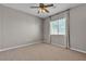 Cozy bedroom with neutral carpet, ceiling fan, and bright, sunny window at 3047 Whispering Crest Dr, Henderson, NV 89052