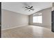 Spacious bedroom with light wood floors, ceiling fan, and a large window with lots of natural light at 3047 Whispering Crest Dr, Henderson, NV 89052