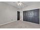 Bedroom featuring plush carpet, ceiling fan, and closet with black doors at 3047 Whispering Crest Dr, Henderson, NV 89052