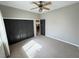 Neutral bedroom with carpet, ceiling fan, closet with black doors, and view to doorway at 3047 Whispering Crest Dr, Henderson, NV 89052
