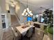 Warm dining space with view to the living room, modern lighting, and stairs at 3047 Whispering Crest Dr, Henderson, NV 89052