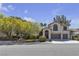 Two-story home with desert landscaping, arched windows, and a front-facing two car garage at 3047 Whispering Crest Dr, Henderson, NV 89052