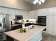 Bright kitchen features stainless steel appliances, spacious island and white cabinetry at 3047 Whispering Crest Dr, Henderson, NV 89052