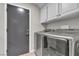 Practical laundry room with washer, dryer, and upper cabinets for efficient organization and ample storage at 3047 Whispering Crest Dr, Henderson, NV 89052