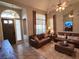 Inviting living room with vaulted ceilings, two leather sofas, tile floors, and a stylish ceiling fan with integrated lighting at 3047 Whispering Crest Dr, Henderson, NV 89052