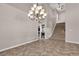 Bright living room with tile flooring, a chandelier, stairs, and a stylish built-in wet bar at 3047 Whispering Crest Dr, Henderson, NV 89052