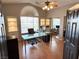 Bright home office featuring a glass-top desk, built-in shelving, and a large window with privacy blinds at 3047 Whispering Crest Dr, Henderson, NV 89052