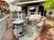 An outdoor kitchen features a built-in grill, countertop, and stacked stone accents, perfect for entertaining at 3047 Whispering Crest Dr, Henderson, NV 89052