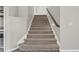 Carpeted staircase with modern railing and lighting leads to the upper level of this beautiful home at 3047 Whispering Crest Dr, Henderson, NV 89052