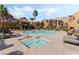 Community pool with a hot tub, surrounded by lounge chairs, palm trees and attractive buildings at 3975 N Hualapai Way # 285, Las Vegas, NV 89129