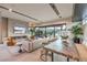 Open-concept living room with modern fireplace, stylish seating, and seamless transition to the outdoor pool and patio area at 4077 Heron Fairway Dr, Las Vegas, NV 89141