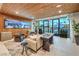 Inviting living space with an accent wood wall, comfortable seating and natural light from expansive windows at 4077 Heron Fairway Dr, Las Vegas, NV 89141