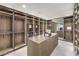 Spacious walk-in closet with custom wood shelving, cabinets, and ample storage for clothes and accessories at 4077 Heron Fairway Dr, Las Vegas, NV 89141