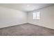 This bedroom features a neutral color palette, window, and plush gray carpeting at 4234 Lunar Canyon Ave, North Las Vegas, NV 89084