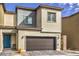 Charming two-story home with a brown two-car garage door, and a blue front door at 4234 Lunar Canyon Ave, North Las Vegas, NV 89084