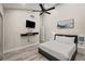 Comfortable bedroom features a ceiling fan, wall-mounted TV, light gray flooring, and modern décor at 4689 Kristen Ln, Las Vegas, NV 89121