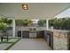 Covered outdoor kitchen features built-in grill, bar seating, and lush landscaping at 4689 Kristen Ln, Las Vegas, NV 89121