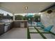 This outdoor kitchen has a built-in grill and mini-fridge, with a view of the pool at 4689 Kristen Ln, Las Vegas, NV 89121